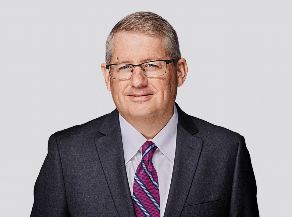 Headshot of Dave Mullin, attorney at Fraser Stryker in Omaha, NE, wearing a black suit jacket, white button-down shirt, and dark red patterned tie.