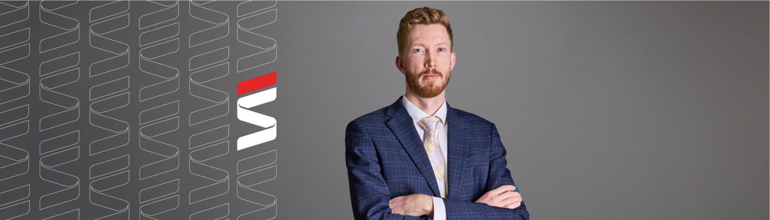 Jacob Craft, Fraser Stryker attorney, wearing a dark blue striped suit jacket, white shirt and multi-colored tie. Fraser Stryker logo icon repeating on the left side of the photo.