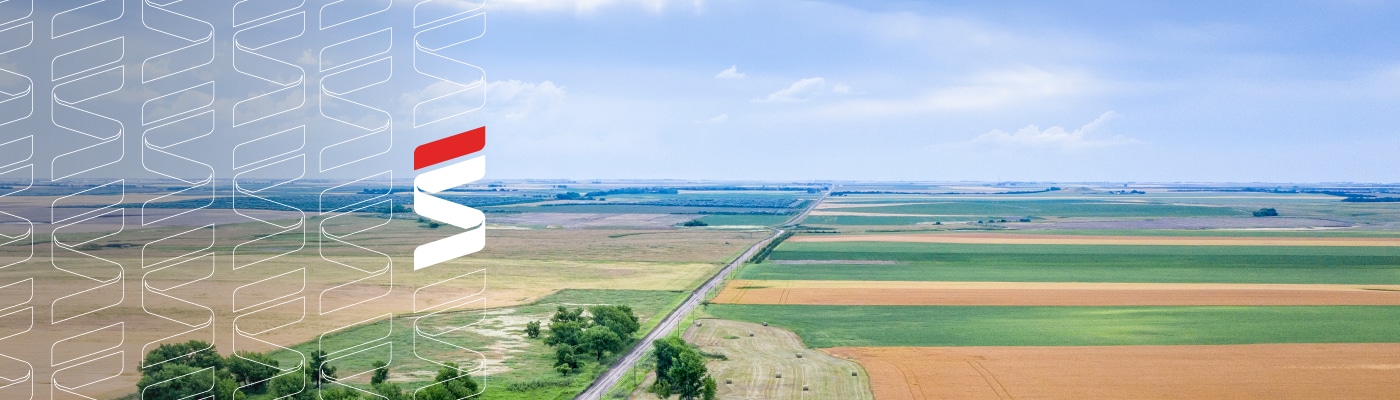 Aerial photo of rural farmland and skyline. Fraser Stryker logo icon repeating on the left side of the photo.