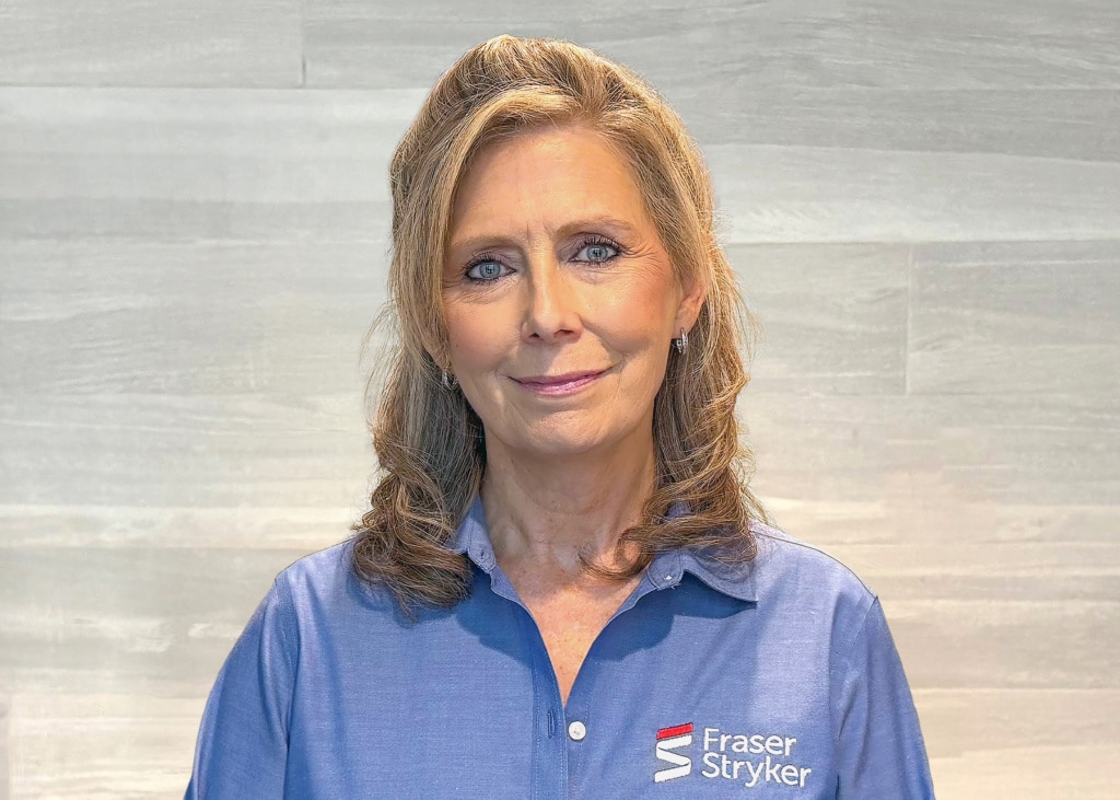 Headshot of Vera Brennan, employee at Fraser Stryker, wearing a blue button down shirt with a white and red Fraser Stryker logo.